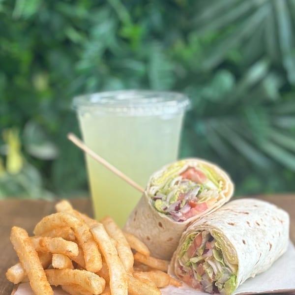C4Eats vegan wraps with fries and a drink, set against a lush green background.